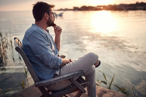 Young Beardy Guy Sitting Alone River Coast Enjoying Sunset Thinking — Stock Photo, Image