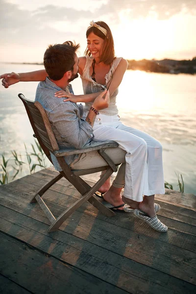 Vrouw Zit Een Schoot Van Een Man Bij Zonsondergang Lachend — Stockfoto