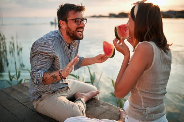 Young Adult Couple Sitting River Sunset Talking Smiling Laughing Eating — Stock Photo, Image