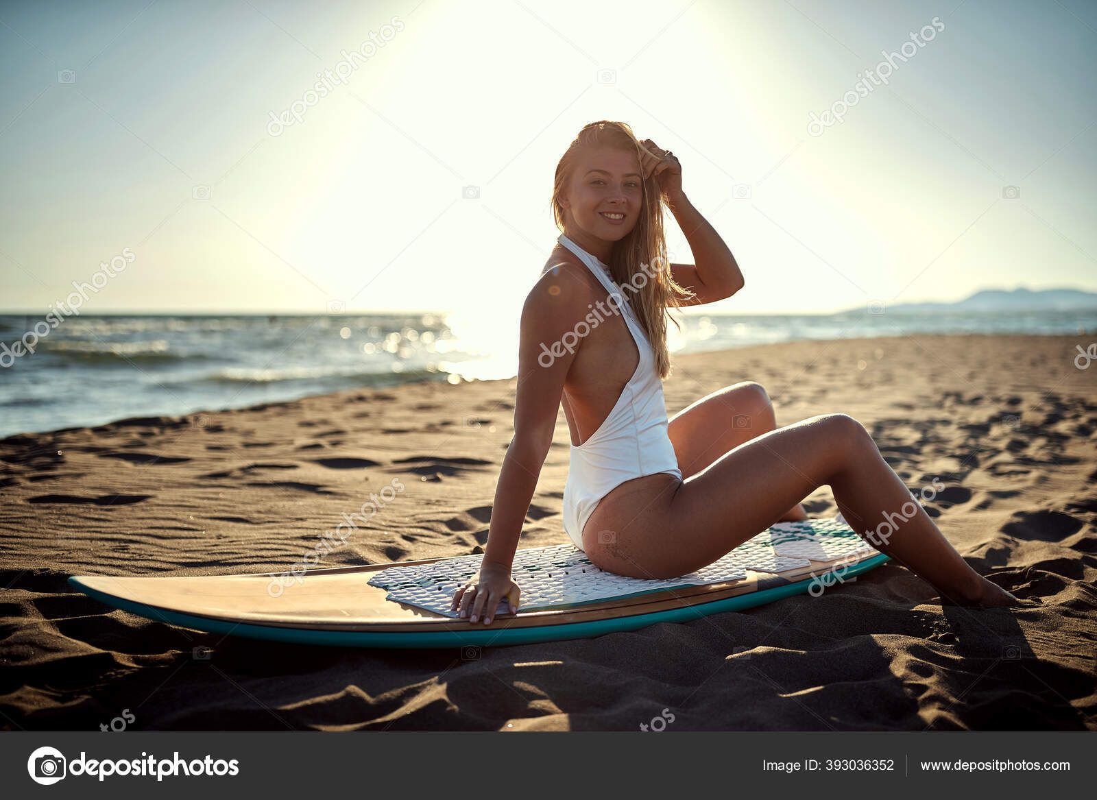 Young Sexy Caucasian Blonde Sitting Surfboard Beach Looking Camera Eye  Stock Photo by ©luckybusiness 393036352