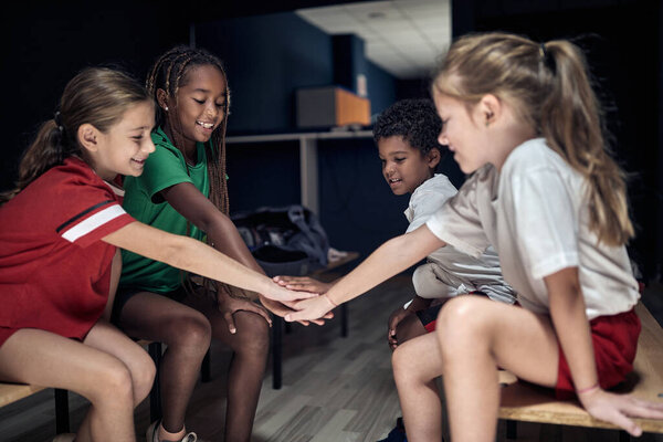 Team of children team doing high five before match or training.