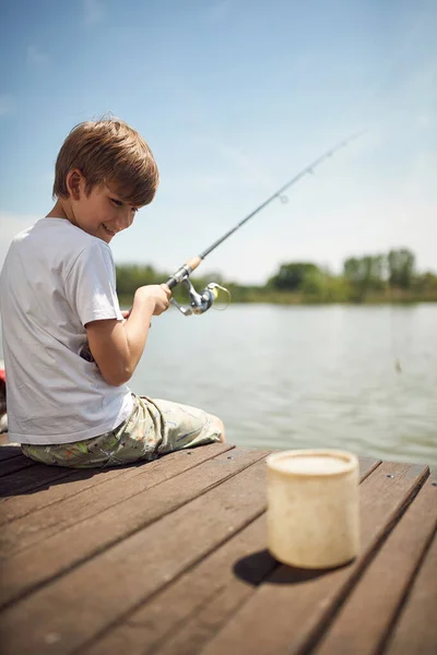 池で夏休みや釣りを楽しんでいる幸せな少年 — ストック写真
