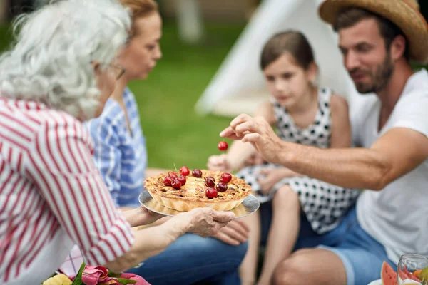 裏庭で一緒に夏を楽しみ パイを食べる若い家族 — ストック写真