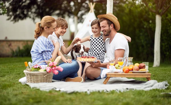 裏庭で一緒に夏を楽しみ パイを食べる幸せな家族 — ストック写真