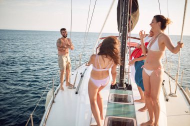 Arkadaşlar güneşli bir günde yatta iyi vakit geçiriyorlar.