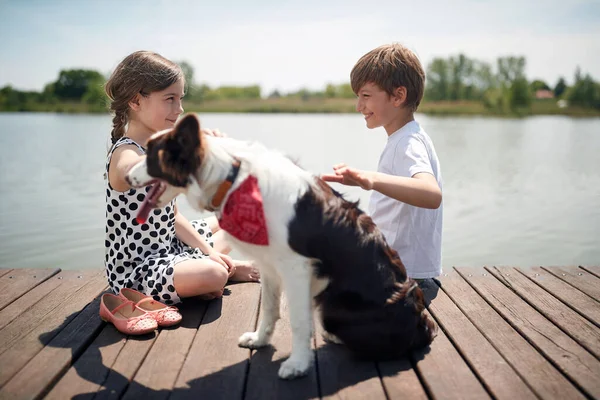 Cute Caucasian Boy Girl Sitting River Smiling Talking Cuddling Dog — Stock Photo, Image