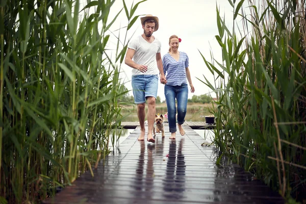Young Adult Caucasian Couple Running Barefoot Wooden Path River Dog — Stock Photo, Image