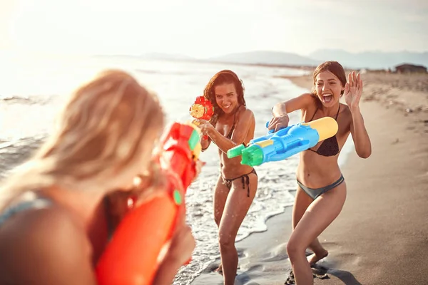 Drei Frauen Besprühen Sich Einem Sandstrand Mit Wasser Aus Wasserpistolen — Stockfoto