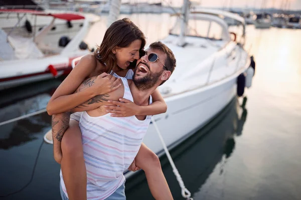 Young couple having fun in the dock on the sunset