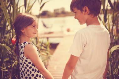 Mutlu erkek ve kız kardeşler Gölün rıhtımında iyi eğlenceler