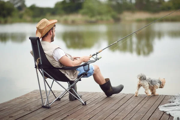 Een Man Geniet Van Vissen Een Steiger Met Zijn Hond — Stockfoto
