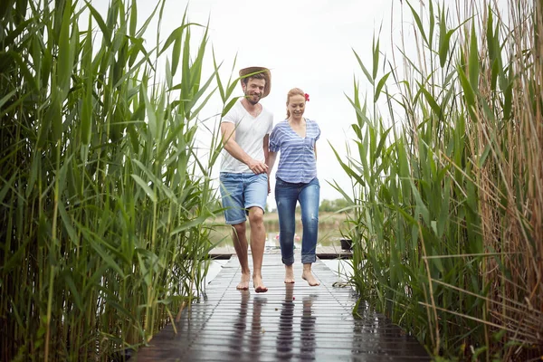 Ehepartner Gehen Barfuß Auf Einem Nassen Steg Des Sees — Stockfoto