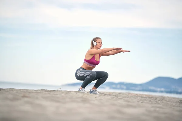 Дівчина Слухає Музику Виконує Вправи Пляжі Молода Жінка Присікає Ноги — стокове фото