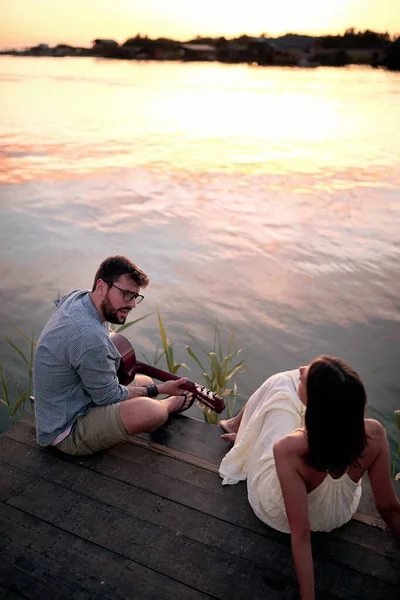 Romantik Çift Güzel Günbatımında Nehirde Gitar Çalıyor — Stok fotoğraf