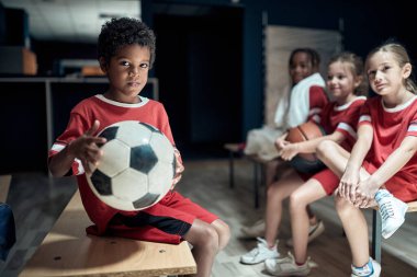 Soyunma odasında antrenman öncesi poz veren küçük futbolcular.
