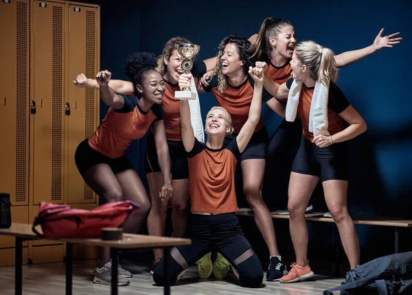 若い女性チームお祝いし 優勝カップとロッカールームにポーズ — ストック写真