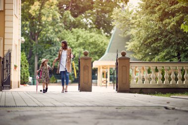 Anne ve kızı okula beraber yürüyorlar.