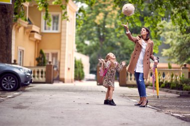 Anne ve kızı okula giderken oyun oynuyorlar.