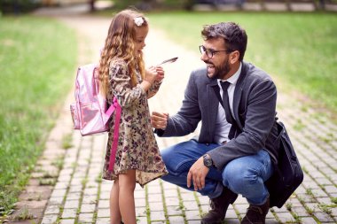 Baba ve kızı birlikte parkta vakit geçiriyorlar.
