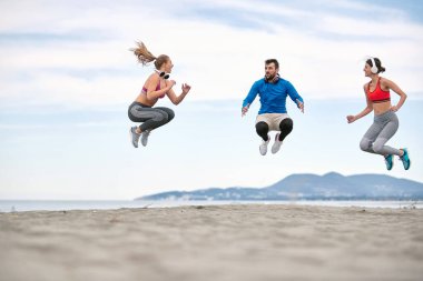 Sahilde kişisel antrenman yapan iki kadın.
