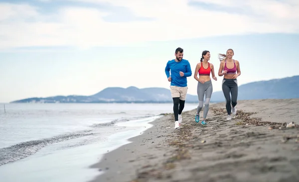 Grupo Tres Personas Corriendo Juntas Playa —  Fotos de Stock