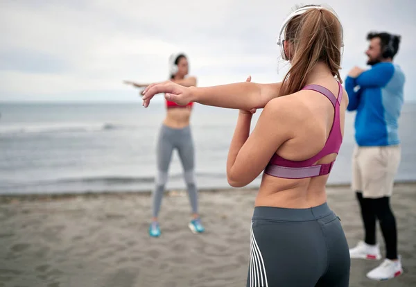 在海滩上一起锻炼的人群 健康的生活方式概念 — 图库照片