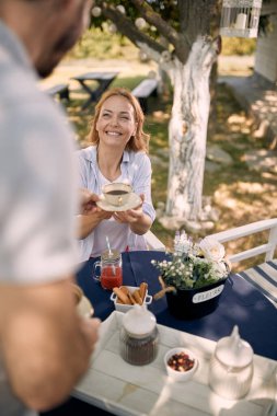 Güzel bir piknik günü. Gülümseyen ebeveynler kırsalda eğleniyor ve birlikte kahve içiyorlar..