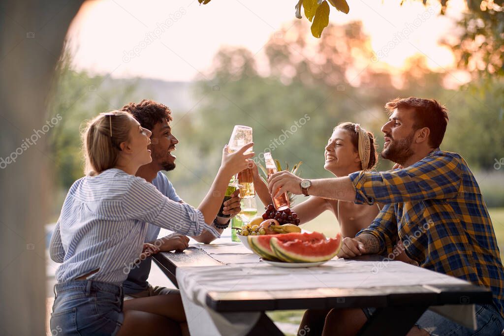 Happy Friends  toasting and drinks  outdoor at sunset.