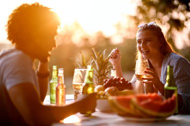 Gülümseyen çift akşamları eğleniyor ve birlikte içiyor..