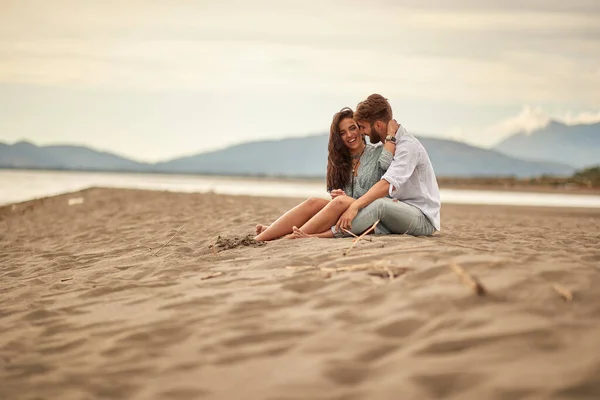 Pareja Joven Enamorada Sentada Abrazo Playa Con Hermoso Clima —  Fotos de Stock