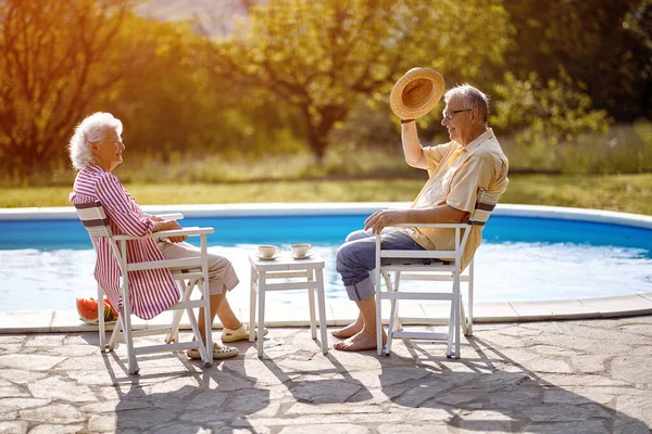 Senior family enjoy on summer holiday near swimming pool together.