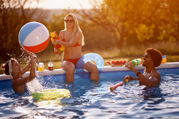 夏休みにプールで水鉄砲を楽しんでいるクレイジーな友人 — ストック写真