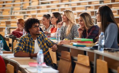 Bir grup bayan öğrenci amfitiyatroda birlikte oturuyorlar.