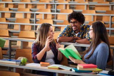 Amfitiyatroda kadın meslektaşlarıyla konuşan bir erkek.