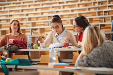 Kadın öğrenciler amfitiyatroda birlikte öğreniyor.