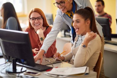 Profesör sınıftaki neşeli öğrencilere yardımcı oluyor.