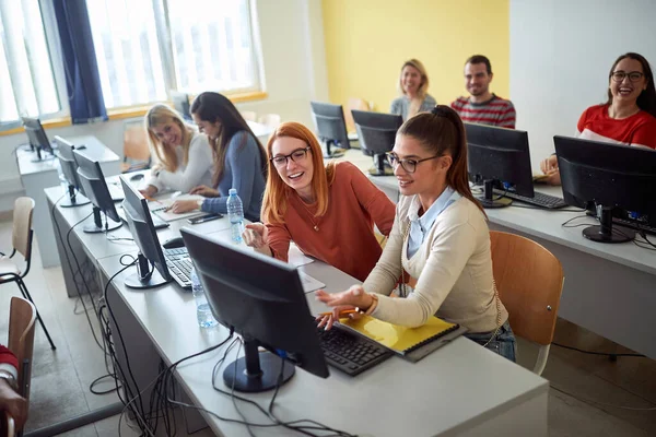 Kaksi Onnellista Tyttöä Collegessa Etsivät Jotain Tietokoneella — kuvapankkivalokuva