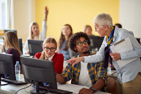 Female professor showing to pupils task on computer