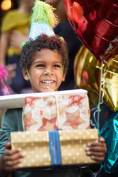 Щасливий Маленький Афроамериканський Хлопчик Посміхається Купою Подарунків Руках — стокове фото