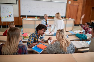 Öğrenci, amfitiyatroda meslektaşına yardım ediyor.