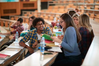 Öğrenciler bir ders arasında amfitiyatroda sohbet ediyorlar.