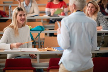 Amfitiyatroda profesörle konuşan bir kız öğrenci.
