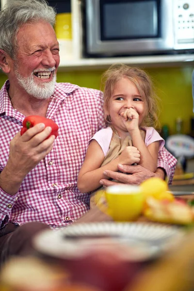 白人のおじいちゃんは孫と膝の上で大声で笑って台所に座り — ストック写真
