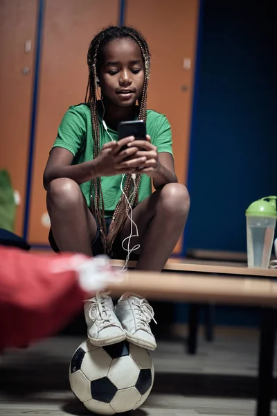 Ein Kleiner Fußballer Genießt Musik Auf Dem Handy Und Wartet — Stockfoto
