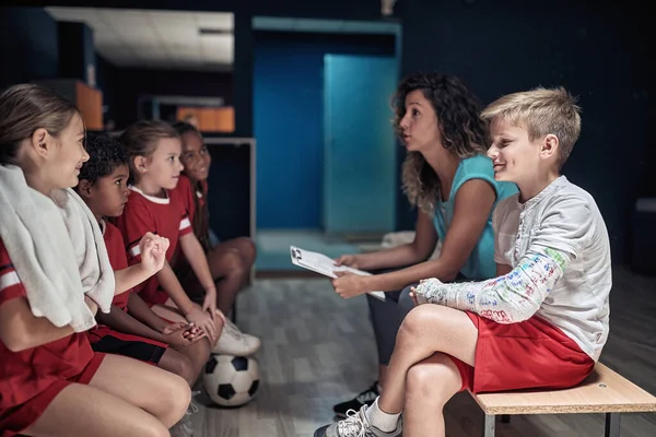 Kindervoetbalteam Hun Vrouwelijke Coach Een Kleedkamer Praten Tactiek — Stockfoto