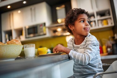 Mutfakta yemek yiyen tatlı bir kız çocuğu.