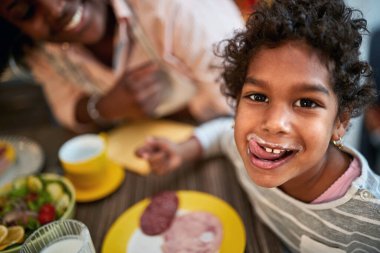 Tatlı bayan çocuk lezzetli bir yemekten sonra dudaklarını yalıyor.