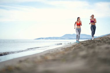 Genç kızlar güzel bir havada sahilde eğitim alırlar.