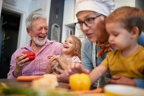 Avós Caucasianos Divertindo Com Seus Netos Cozinha Brincando Com Vegetebles — Fotografia de Stock
