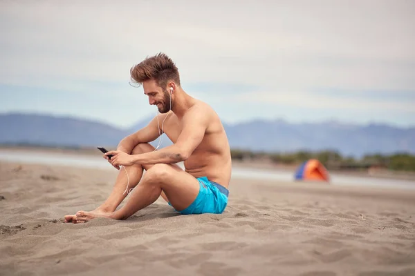 Mladý Pohledný Muž Sedí Pláži Krásného Počasí — Stock fotografie